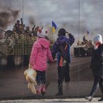 
              A woman walks by a large print at a photographic memorial for those killed in the confrontation between Ukraine's military and the pro-Russia separatist forces in Sievierodonetsk, Luhansk region, eastern Ukraine, Wednesday, Feb. 23, 2022. Ukraine urged its citizens to leave Russia, and Europe braced for further confrontation Wednesday after tensions escalated dramatically when Russia's leader received authorization to use military force outside his country and the West responded with a raft of sanctions. (AP Photo/Vadim Ghirda)
            