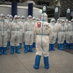 
              Olympic workers in protective clothing have a meeting at Beijing Capital International Airport after the 2022 Winter Olympics, Monday, Feb. 21, 2022, in Beijing, China. (AP Photo/Alessandra Tarantino)
            
