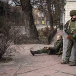 
              A Ukrainian soldier sits injured in cross fire inside the city of Kyiv, Ukraine, Friday, Feb. 25, 2022. Russia pressed its invasion of Ukraine to the outskirts of the capital Friday after unleashing airstrikes on cities and military bases and sending in troops and tanks from three sides in an attack that could rewrite the global post-Cold War security order. (AP Photo/Emilio Morenatti)
            