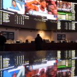 
              People make bets at the sportsbook at the Ocean Casino Resort, on Thursday, Feb. 10, 2022, in Atlantic City, N.J. The American Gaming Association estimates more than 31 million Americans will bet on this year's Super Bowl NFL football game. (AP Photo/Wayne Parry)
            