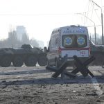 
              An ambulance parked near a barricade and Ukrainian armored vehicles in a street in Kyiv, Ukraine, Saturday, Feb. 26, 2022. Russian troops stormed toward Ukraine's capital Saturday, and street fighting broke out as city officials urged residents to take shelter. (AP Photo/Efrem Lukatsky)
            