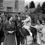 
              FILE - Britain's Prince Charles, watched by, from left, King George VI, Princess Elizabeth, Prince Philip, Princess Margaret and Queen Elizabeth, sits on a sculpture of a deer in the grounds of Balmoral Castle, Scotland, Aug. 1951. Queen Elizabeth II will mark 70 years on the throne Sunday, Feb. 6, 2022, an unprecedented reign that has made her a symbol of stability as the United Kingdom navigated an age of uncertainty.  (AP Photo, File)
            
