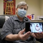 
              Ray Hoffman, who is immune-compromised, holds a photo of himself taken in 2020 when he received a liver transplant, Thursday, Jan. 20, 2022, after he was given a two-shot dose of AstraZeneca's Evusheld, the first set of antibodies grown in a lab to prevent COVID-19, at a University of Washington Medicine clinic in Seattle. The drug is supposed to give patients like Hoffman, who can't make his own virus-fighters due to taking strong immune-suppressing drugs after liver and kidney transplants, some protection against COVID-19 for six months. (AP Photo/Ted S. Warren)
            