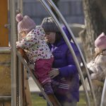 
              A woman helps a baby climb a ladder in a park in Sievierodonetsk, Luhansk region, eastern Ukraine, Wednesday, Feb. 23, 2022. The head of Ukraine's National Security and Defense Council called for a nationwide state of emergency — subject to parliamentary approval. (AP Photo/Vadim Ghirda)
            
