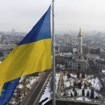 
              A Ukrainian national flag waves over the center of Kharkiv, Ukraine's second-largest city, Wednesday, Feb. 16, 2022, just 40 kilometers (25 miles) from some of the tens of thousands of Russian troops massed at the border of Ukraine, feels particularly perilous. As Western officials warned a Russian invasion could happen as early as today, the Ukrainian President Zelenskyy called for a Day of Unity, with Ukrainians encouraged to raise Ukrainian flags across the country. (AP Photo/Mstyslav Chernov)
            