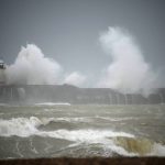 
              Waves crash over the Newhaven harbour breakwater and lighthouse, as Storm Eunice hits Newhaven, on the south coast of England, Friday, Feb. 18, 2022. Millions of Britons are being urged to cancel travel plans and stay indoors Friday amid fears of high winds and flying debris as the second major storm this week prompted a rare "red" weather warning, meaning there is a danger to life, across southern England. (AP Photo/Matt Dunham)
            