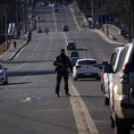 
              A police officer stands guard at a road leading to central Kyiv, Ukraine, Monday, Feb. 28, 2022. Explosions and gunfire that have disrupted life since the invasion began last week appeared to subside around Kyiv overnight, as Ukrainian and Russian delegations met Monday on Ukraine’s border with Belarus. It's unclear what, if anything, those talks would yield. (AP Photo/Emilio Morenatti)
            