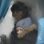 
              A woman and child peer out of the window of a bus as they leave Sievierodonetsk, the Luhansk region, in eastern Ukraine, Thursday, Feb. 24, 2022. Russian President Vladimir Putin on Thursday announced a military operation in Ukraine and warned other countries that any attempt to interfere with the Russian action would lead to "consequences you have never seen." (AP Photo/Vadim Ghirda)
            