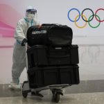 
              A volunteer moves a passenger's baggage at Beijing Capital International Airport after the conclusion of the 2022 Winter Olympics, Sunday, Feb. 20, 2022, in Beijing. (AP Photo/Ashley Landis)
            