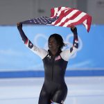 
              Erin Jackson of the United States hoists an American flag after winning the gold medal in the speedskating women's 500-meter race at the 2022 Winter Olympics, Sunday, Feb. 13, 2022, in Beijing. (AP Photo/Sue Ogrocki)
            