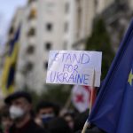 
              A protestor holds up a sign next to an EU flag during a demonstration in front of the Russian embassy in Paris, France, Tuesday, Feb. 22, 2022. World leaders are getting over the shock of Russian President Vladimir Putin ordering his forces into separatist regions of Ukraine and they are focusing on producing as forceful a reaction as possible. Germany made the first big move Tuesday and took steps to halt the process of certifying the Nord Stream 2 gas pipeline from Russia. (AP Photo/Francois Mori)
            