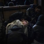 
              A baby sleeps while people trying to flee Ukraine wait for trains inside Lviv railway station, Monday, Feb. 28, 2022, in Lviv, west Ukraine. Russia's military assault on Ukraine has entered its fifth day, forcing hundreds of thousands of Ukrainians and foreign residents to escape from war and seek refuge in neighboring countries. (AP Photo/Bernat Armangue)
            