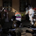 
              Defense forces and police give a guard of honor as the body of Lata Mangeshkar, lies outside her home in Mumbai, India, Sunday, Feb.6, 2022. The legendary Indian singer with a prolific, groundbreaking catalog and a voice recognized by a billion people in South Asia, died Sunday morning of multiple organ failure. She was 92. (AP Photo/Rafiq Maqbool)
            