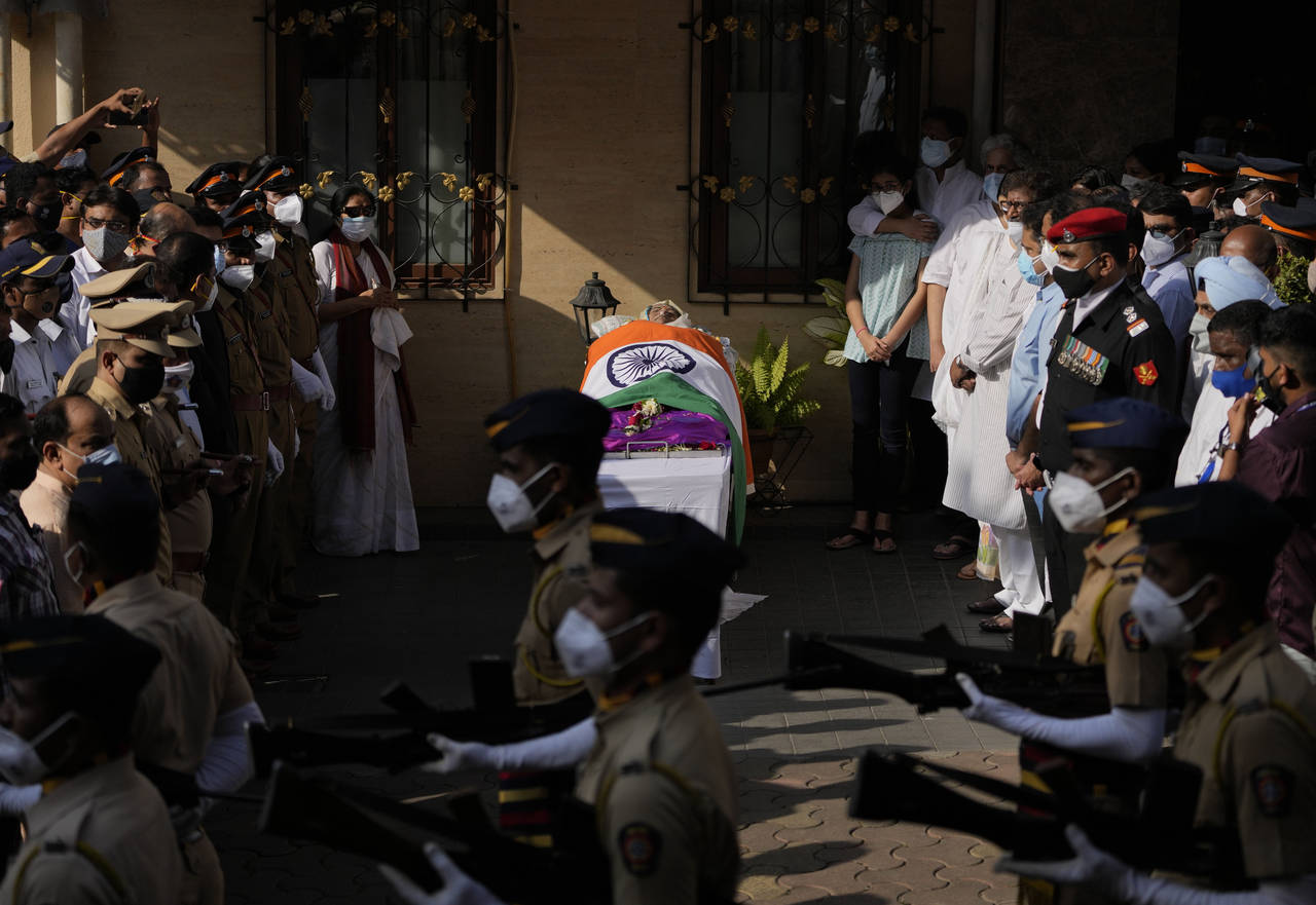 Defense forces and police give a guard of honor as the body of Lata Mangeshkar, lies outside her ho...