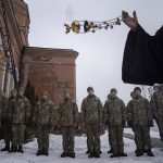 
              An Orthodox priest blesses Ukrainian Military Air Force University cadets after a monthly memorial service for soldiers who were killed during the fighting against Russia-backed separatists in eastern Ukraine, in Kharkiv, Ukraine, Thursday, Feb. 3, 2022. Russia maintains it has no intention to attack its neighbor, but demands that NATO won't expand to Ukraine and other ex-Soviet nations or deploy weapons there. It also wants the alliance to roll back its deployments to Eastern Europe. (AP Photo/Evgeniy Maloletka)
            