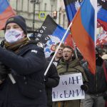 
              Pro-Kremlin activists and students rally with Russian and Donetsk People republic flags and a poster that reads: "Donetsk Luhansk People republics we are together" celebrating the recognition of rebel-controlled regions in Donbas, at the Palace Square in St. Petersburg, Russia, Wednesday, Feb. 23, 2022. About five hundred people got together at St. Peterburg's main Palace Square and then proceeded along the streets of the city carrying flags of Russia and of the two self-proclaimed republics in Eastern Ukraine that have been recognised as independent by the Russian Government this week. (AP Photo/Ivan Petrov)
            