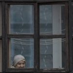 
              A woman looks out of the window of a balcony in Sievierodonetsk, in the Luhansk region, eastern Ukraine, Friday, Feb. 18, 2022. Spiking tensions in eastern Ukraine on Friday aggravated Western fears of a Russian invasion and a new war in Europe, with a humanitarian convoy hit by shelling and pro-Russian rebels evacuating civilians from the conflict zone. (AP Photo/Vadim Ghirda)
            