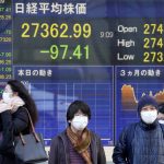 
              Masked pedestrians move past a monitor showing Japan's Nikkei 225 index, at a securities firm in Tokyo, Thursday, Feb. 17, 2022. Asian stock markets followed Wall Street higher Thursday after Federal Reserve policymakers indicated they are leaning toward more decisive action on inflation but set no firm targets. (AP Photo/Shuji Kajiyama)
            