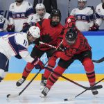 
              Canada's Micah Zandee-Hart (28) and United States' Abby Roque (11) go for the puck during the women's gold medal hockey game at the 2022 Winter Olympics, Thursday, Feb. 17, 2022, in Beijing. (AP Photo/Petr David Josek)
            