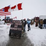 People block highway 75 with heavy trucks and farm equipment and access to the Canada-United States border crossing at Emerson, Manitoba, Thursday, Feb. 10, 2022. The blockade was set up to rally against provincial and federal COVID-19 vaccine mandates and in support of Ottawa protestors. (John Woods/The Canadian Press via AP)