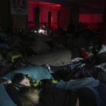 
              People sleep in the improvised bomb shelter in a sports center, which can accommodate up to 2000 people, in Mariupol, Ukraine, late Sunday, Feb. 27, 2022. Explosions and gunfire that have disrupted life since the invasion began last week appeared to subside around Kyiv overnight, as Ukrainian and Russian delegations prepared to meet Monday, Feb. 28, 2022 on Ukraine's border with Belarus. It's unclear what, if anything, those talks would yield. Terrified Ukrainian families huddled in shelters, basements or corridors, waiting to find out. (AP Photo/Evgeniy Maloletka)
            