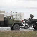 
              Ukrainian Army soldiers prepare to tow a damaged military truck in Kyiv, Ukraine, Friday, Feb. 25, 2022. Russia is pressing its invasion of Ukraine to the outskirts of the capital after unleashing airstrikes on cities and military bases and sending in troops and tanks from three sides. (AP Photo/Efrem Lukatsky)
            