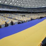 
              A 200 meter long Ukrainian flag is unfolded at the Olympiyskiy stadium in Kyiv, Ukraine, Wednesday, Feb. 16, 2022. As Western officials warned a Russian invasion could happen as early as today, the Ukrainian President Zelenskyy called for a Day of Unity, with Ukrainians encouraged to raise Ukrainian flags across the country. (AP Photo/Efrem Lukatsky)
            
