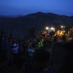 
              FILE - People stand next to tractors at nightfall as they observe the rescue mission of a 5 year old boy who fell into a well, in the northern village of Ighran in Morocco's Chefchaouen province, Friday, Feb. 4, 2022. The death of a 5-year-old boy trapped for days in the dark depths of a well symbolizes for many villagers a curse that haunts their remote mountainous region in northern Morocco. Rif is dirt poor, neglected and dependent on its illegal cannabis crop to survive. Rayan’s plight riveted world attention during five days of vain efforts to save him. The well that swallowed Rayan was dug by his father in a vain bid to forage for water so he could grow cannabis, or marijuana. Such wells dot the rugged Rif region. (AP Photo/Mosa'ab Elshamy, File)
            