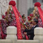 
              FILE - Chinese President Xi Jinping adjusts wreaths of flowers after he paid respects to the Monument to the People's Heroes during a ceremony to mark Martyr's Day at Tiananmen Square in Beijing, Thursday, Sept. 30, 2021. Xi was dubbed "chairman of everything" after he put himself in charge of economic, propaganda and other major functions. That reversed a consensus for the ruling inner circle to avoid power struggles by sharing decision-making. (AP Photo/Andy Wong, File)
            