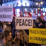 
              Protestors take part in a demonstration against Russia's military intervention in Ukraine at the Sol square in Madrid, Spain, Friday, Feb. 25, 2022. Russian troops bore down on Ukraine's capital Friday, with gunfire and explosions resonating ever closer to the government quarter, in an invasion of a democratic country that has fueled fears of wider war in Europe and triggered worldwide efforts to make Russia stop. (AP Photo/Manu Fernandez)
            