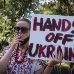 
              A protestor holds a placard at a small demonstration held by Ukrainians, Russians, and Kenyans against Russia's invasion of Ukraine, in front of the Russian embassy in Nairobi, Kenya, Saturday, Feb. 26, 2022. Russian troops closed in on Ukraine's capital as explosions and street fighting sent Kyiv residents seeking shelter or fleeing the city. (AP Photo)
            