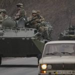 
              Ukrainian servicemen sit atop armored personnel carriers driving on a road in the Donetsk region, eastern Ukraine, Thursday, Feb. 24, 2022. Russian President Vladimir Putin on Thursday announced a military operation in Ukraine and warned other countries that any attempt to interfere with the Russian action would lead to "consequences you have never seen." (AP Photo/Vadim Ghirda)
            