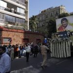 
              The body of Lata Mangeshkar, is taken for funeral procession outside her house in Mumbai, India, Sunday, Feb.6, 2022. The legendary Indian singer with a prolific, groundbreaking catalog and a voice recognized by a billion people in South Asia, died Sunday morning of multiple organ failure. She was 92. (AP Photo/Rafiq Maqbool)
            