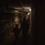 
              A family walks out of a basement used as shelter during an air-raid alarm in Novoiavorisk, western Ukraine, Sunday, March 13, 2022. Waves of Russian missiles pounded a military training base close to Ukraine's western border with NATO member Poland. (AP Photo/Bernat Armangue)
            