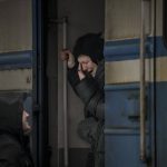 
              A woman on a Lviv bound train cries while she bids goodbye to a man in Kyiv, Ukraine, Saturday, March 12, 2022. Fighting raged in the outskirts of Ukraine's capital, Kyiv, and Russia kept up its bombardment of other resisting cities. (AP Photo/Vadim Ghirda)
            