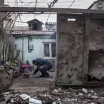 
              A man lights a fire under the kettle in a yard of an apartment building hit by shelling in Mariupol, Ukraine, Monday, March 7, 2022. (AP Photo/Evgeniy Maloletka)
            