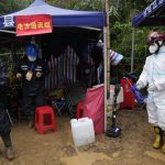 
              Workers supporting the rescue and search effort wash up at a disinfecting station near the China Eastern crash site Thursday, March 24, 2022, in Molang village, in southwestern China's Guangxi province. The search area was expanded Thursday in a "blanket search" for the second black box from a China Eastern passenger plane that crashed in southern China with 132 people on board earlier this week, state media said (AP Photo/Ng Han Guan)
            