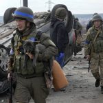 
              A Ukrainian soldier carries a dog saved from under the ruins of houses destroyed by the Russian forces in Irpin close to Kyiv, Ukraine, Thursday, March 31, 2022. The more than month-old war has killed thousands and driven more than 10 million Ukrainians from their homes including almost 4 million from their country. (AP Photo/Efrem Lukatsky)
            