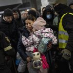 
              Displaced people queue to get on a train to Poland, inside Lviv railway station, in Lviv, western Ukraine, Thursday, March 3, 2022, in Lviv. (AP Photo/Bernat Armangue)
            