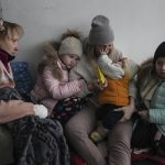 
              Women and children sit on the floor of a corridor in a hospital in Mariupol, eastern Ukraine Friday, March 11, 2022. Mariupol has been under siege for over a week, with no electricity, gas or water. Repeated efforts to evacuate people from the city of 430,000 have fallen apart as humanitarian convoys come under shelling. (AP Photo/Evgeniy Maloletka)
            