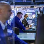 In this photo provided by the New York Stock Exchange, traders work on the floor, Monday, March 7, 2022. Stocks are tumbling on Wall Street Monday as another big leap for oil prices threatens to squeeze inflation's grip on the global economy. (Courtney Crow/New York Stock Exchange via AP)