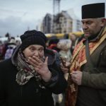 
              A military priest tries to comfort a crying woman who was evacuated from Irpin, at a triage point in Kyiv, Ukraine, Wednesday, March 9, 2022. A Russian airstrike devastated a maternity hospital Wednesday in the besieged port city of Mariupol amid growing warnings from the West that Moscow's invasion is about to take a more brutal and indiscriminate turn. (AP Photo/Vadim Ghirda)
            