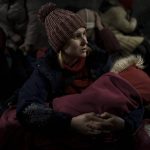 
              Aleksandra Tytywnnik holds her daughter as she sits inside the Lviv railway station waiting for a train to flee Ukraine, in Lviv, western Ukraine, Friday, March 4, 2022. (AP Photo/Felipe Dana)
            