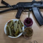 
              A machine gun of a Ukrainian soldier rests next to condiments for lunch in the outskirts of Kyiv, Ukraine, Thursday, March 31, 2022. (AP Photo/Rodrigo Abd)
            