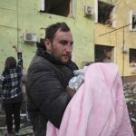 
              A man holds a baby during an evacuation from a maternity hospital damaged by a shelling attack in Mariupol, Ukraine, Wednesday, March 9, 2022. Associated Press journalists, who have been reporting from inside blockaded Mariupol since early in the war, documented this attack on the hospital and saw the victims and damage firsthand. They shot video and photos of several bloodstained, pregnant mothers fleeing the blown-out maternity ward, medics shouting, children crying. (AP Photo/Evgeniy Maloletka)
            