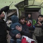 
              A man carries his child away from the damaged by shelling maternity hospital in Mariupol, Ukraine, Wednesday, March 9, 2022. A Russian attack has severely damaged a maternity hospital in the besieged port city of Mariupol, Ukrainian officials say. (AP Photo/Evgeniy Maloletka)
            