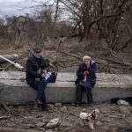 
              A couple sit on the ruble of a destroyed bridge after crossing the Irpin river in the outskirts of Kyiv, Ukraine, Saturday, March 5, 2022. (AP Photo/Emilio Morenatti)
            