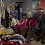 
              Ukrainians pick clothes inside a cinema turned aid center in Lviv, western Ukraine, Saturday, March 12, 2022, in Lviv. Russia's war on Ukraine is now in its third week, the war has expanded to areas in western Ukraine, closer to NATO members Poland and Romania. The war has forced more than 2.5 million people to flee Ukraine. (AP Photo/Bernat Armangue)
            