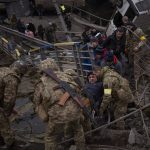 
              Ukrainian soldiers help a man on a wheelchair as people try to flee crossing the Irpin river in the outskirts of Kyiv, Ukraine, Saturday, March 5, 2022. (AP Photo/Emilio Morenatti)
            