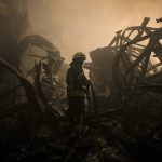 
              A Ukrainian firefighter drags a hose inside a large food products storage facility which was destroyed by an airstrike in the early morning hours on the outskirts of Kyiv, Ukraine, Sunday, March 13, 2022. Waves of Russian missiles pounded a military training base close to Ukraine's western border with NATO member Poland, killing 35 people, following Russian threats to target foreign weapon shipments that are helping Ukrainian fighters defend their country against Russia's grinding invasion.(AP Photo/Vadim Ghirda)
            